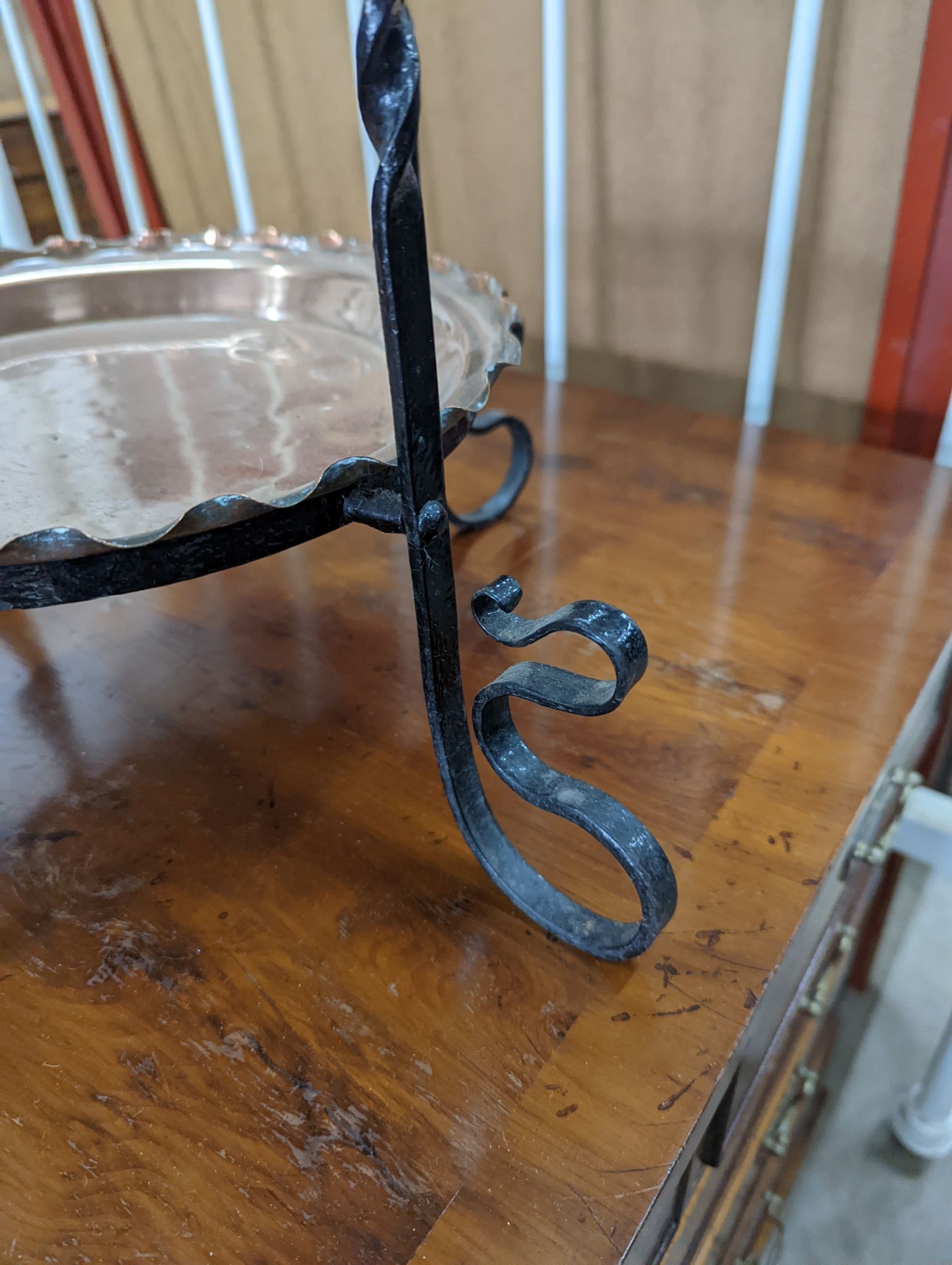 An early 20th century wrought iron and copper three tiered cake stand